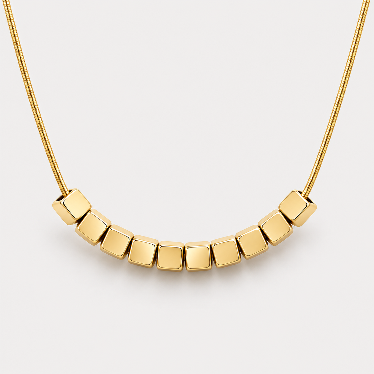 Collier Éclat cubes en acier inoxydable, finition dorée — détail du motif