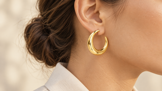 Créole en croissant en acier inoxydable doré, polie, portée à l'oreille avec les cheveux attachés