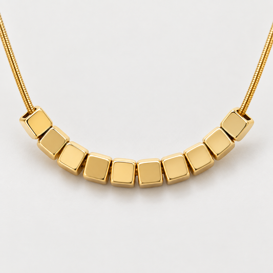 Collier Éclat cubes en acier inoxydable, finition dorée — vue studio